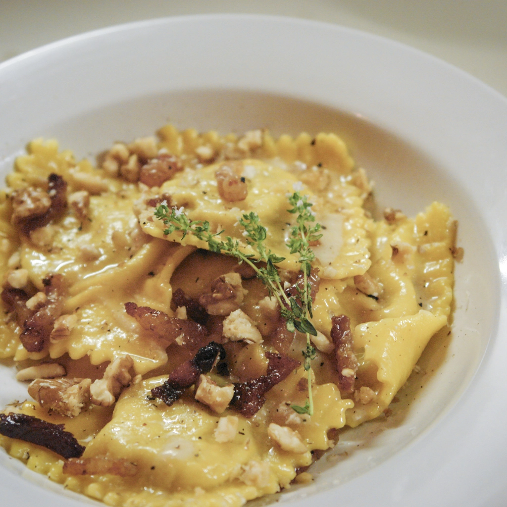 Ravioli alle noci con crema di formaggio, guanciale e timo