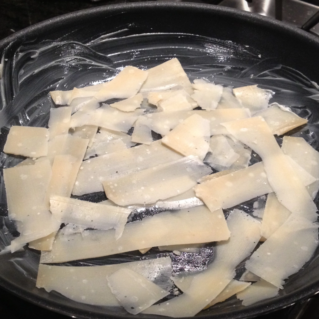 Primo strato di parmigiano su padella imburrata