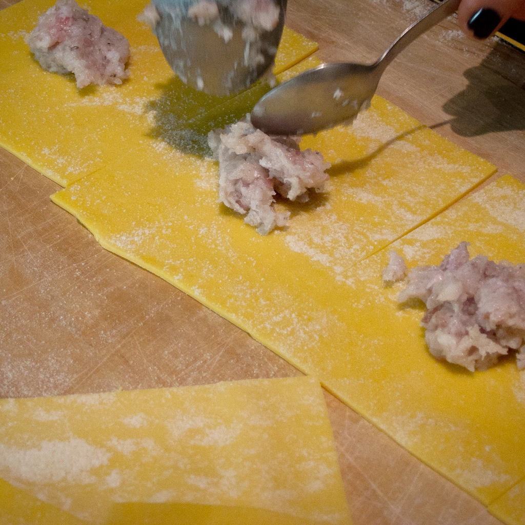 Disporre un po' del composto di branzino e guanciale in ogni quadrato di pasta