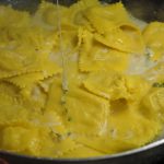Scolare i ravioli e passarli in padella con la crema di formaggio